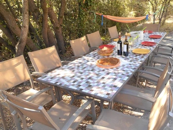 Le salon de jardin sous les arbres près de la piscine