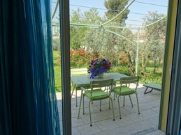 Vue de la chambre sur la terrasse et jardin