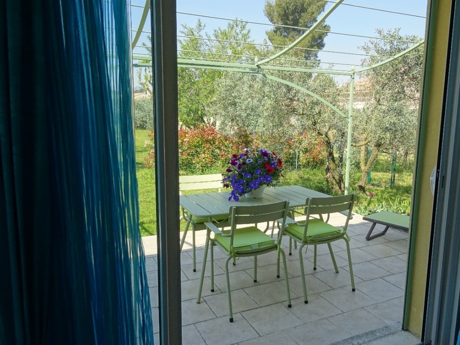 Vue de la chambre sur la terrasse et jardin