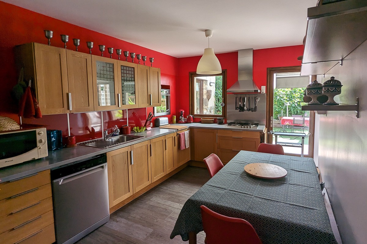 La cuisine séparée très bien équipée, donnant sur le jardin