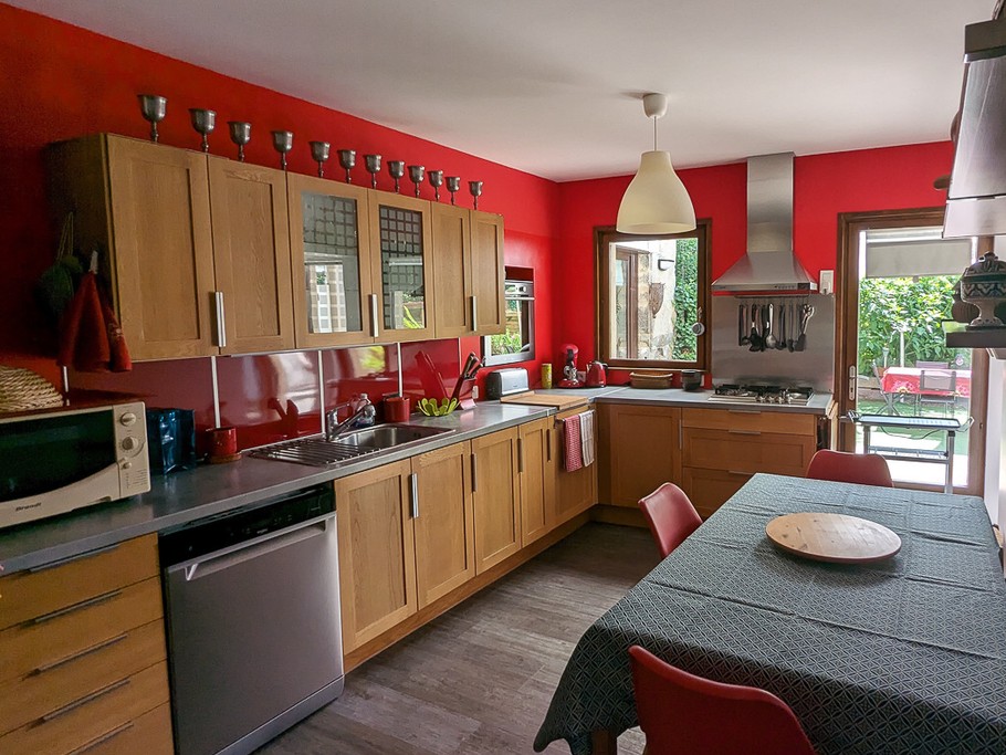 La cuisine séparée très bien équipée, donnant sur le jardin