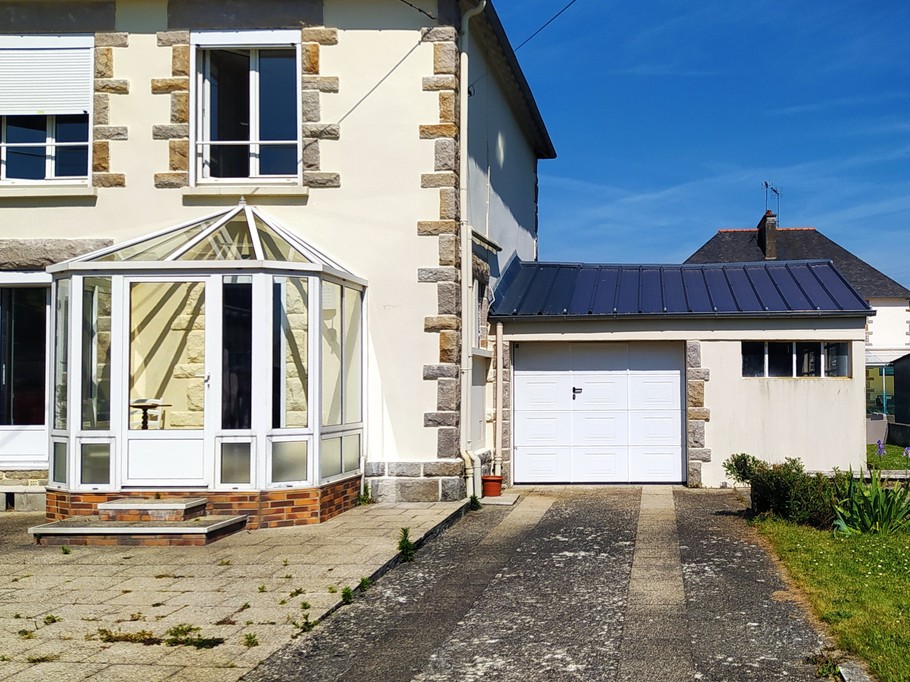 Façade avant de la maison avec cour, stationnement privatif extérieur devant le garage. Garage sécurisé pour stocker vos vélos, poussettes, paddle, etc.
