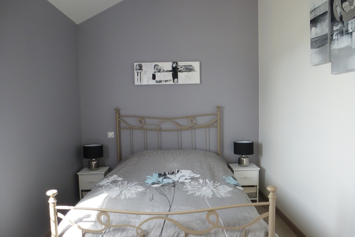 Chambre grise avec lit double (140), placard et TV.