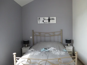 Chambre grise avec lit double (140), placard et TV.