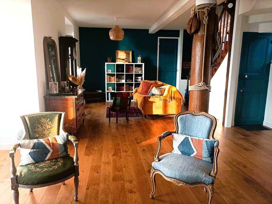 Grande pièce de vie avec 2 salons, un poêle à bois, un séjour dans la véranda vue mer.