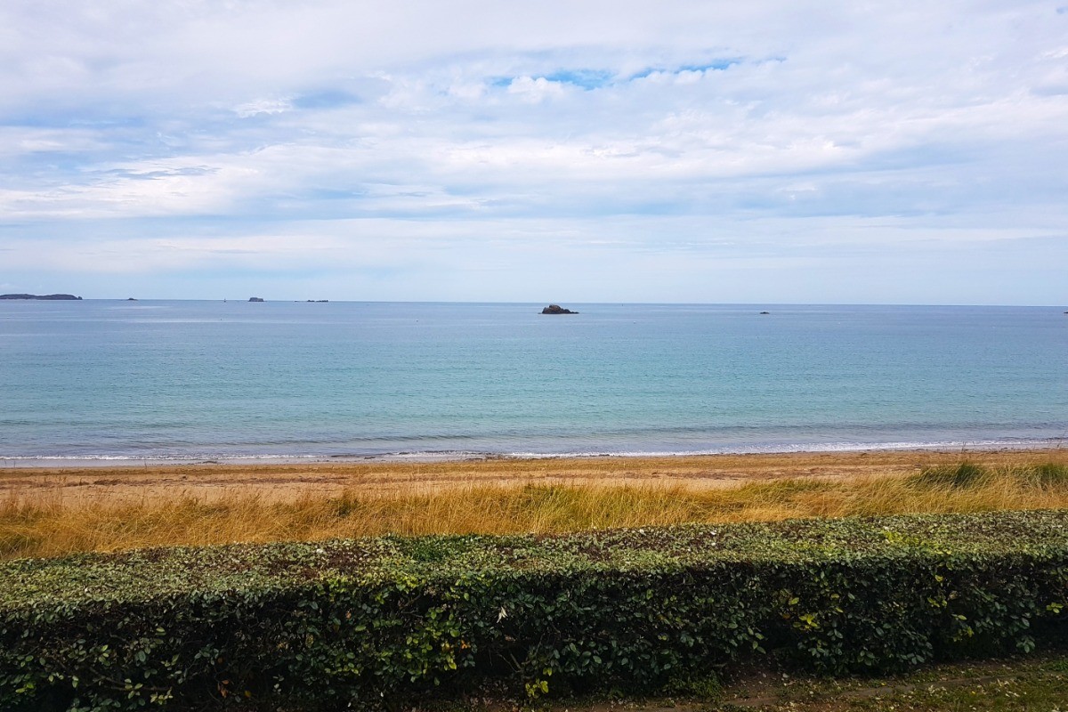 Vue mer depuis la véranda et accès direct à la plage du Minihic à Saint-Malo depuis la résidence. Jardin commun à la résidence en contre bas.