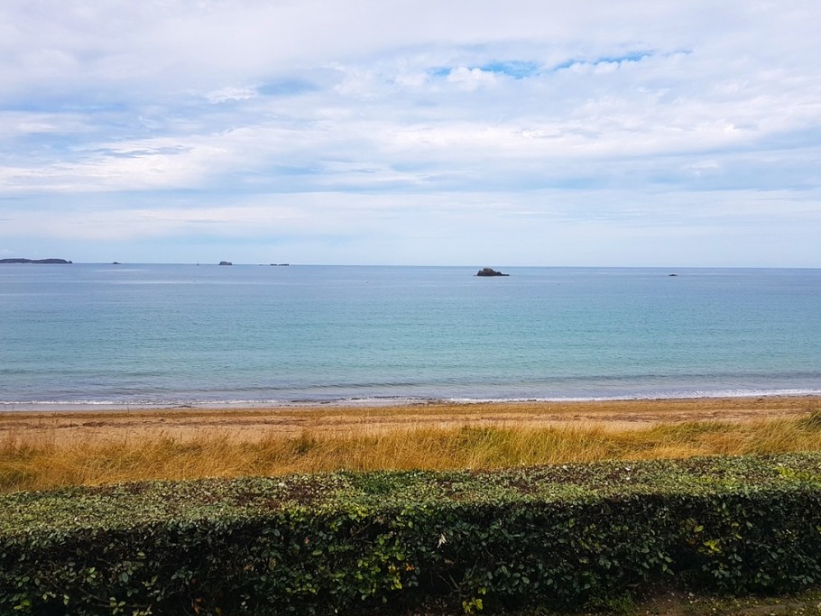 Vue mer depuis la véranda et accès direct à la plage du Minihic à Saint-Malo depuis la résidence. Jardin commun à la résidence en contre bas.