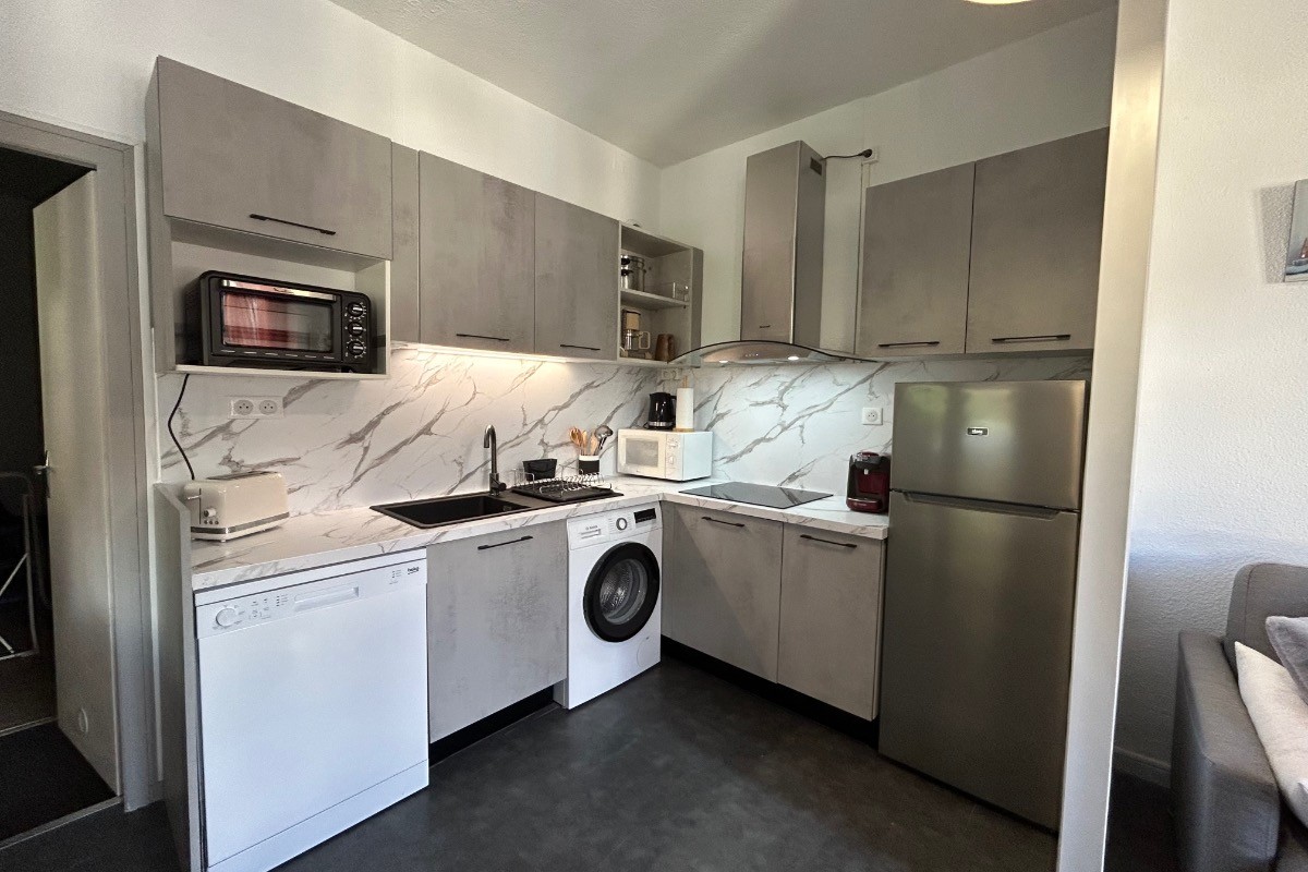Coin cuisine avec combi frigo congélateur, lave-vaisselle, lave-linge, micro-ondes, mini four