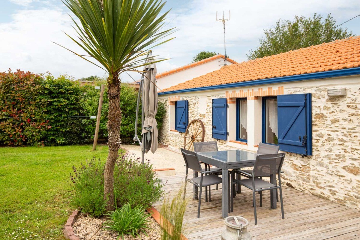 Jardin privatif avec terrasse, salon de jardin, parasol, transats, fils à linge et barbecue.