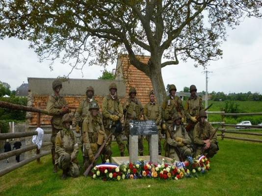 Reconstiteurs devant la stéle du souvenir DES QUELQUES PARAS PERDU SUR OMAHA BEACH