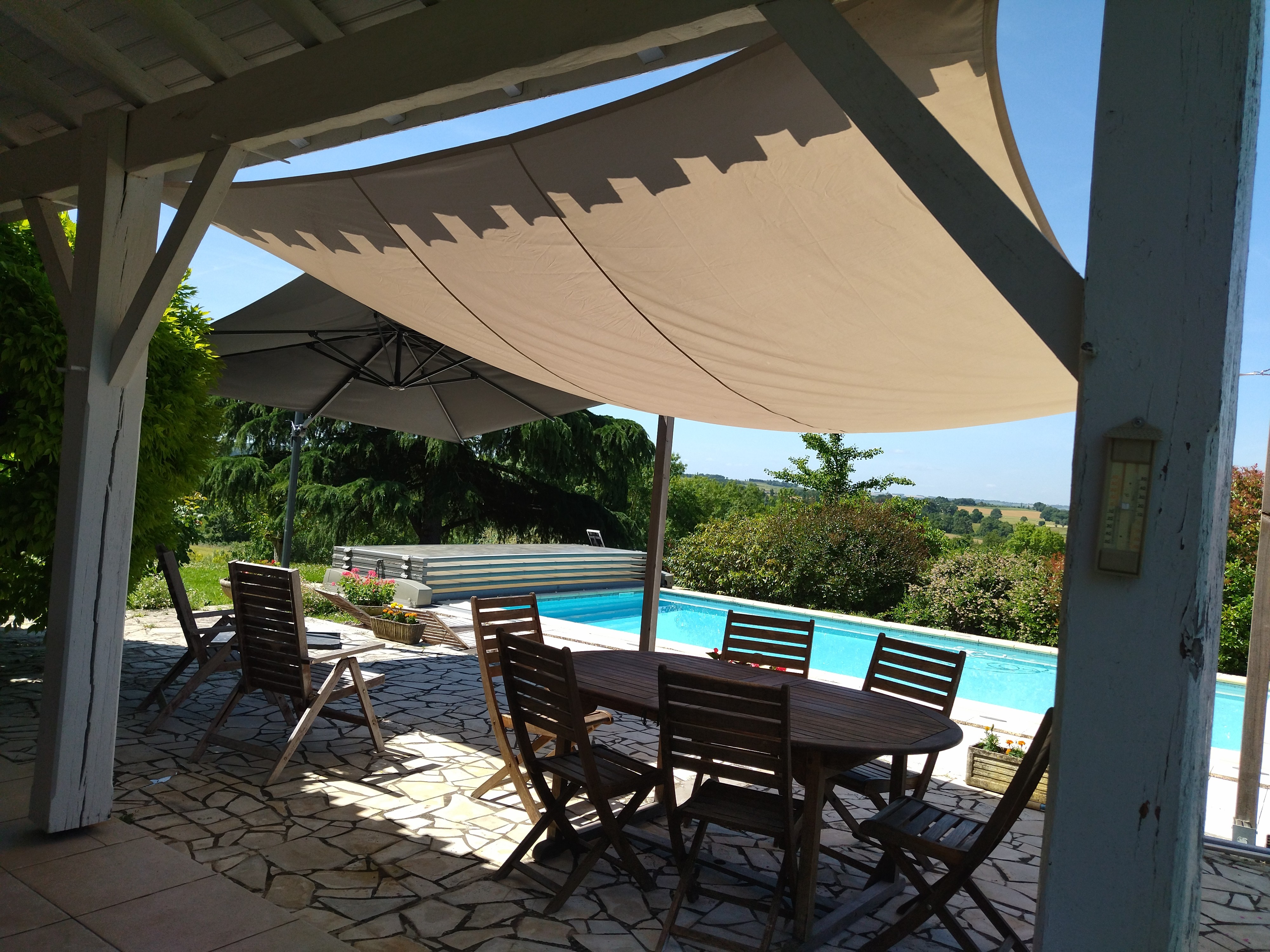 Terrasse avec la toile d'ombrage et le Parasol.