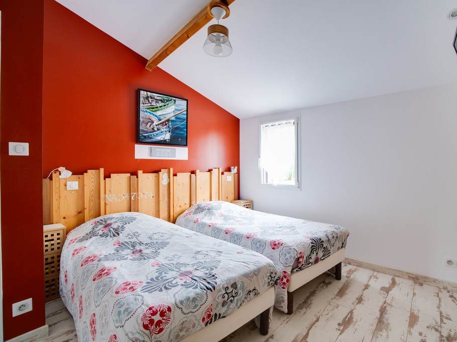Chambre avec deux lits simple et écran plat.
