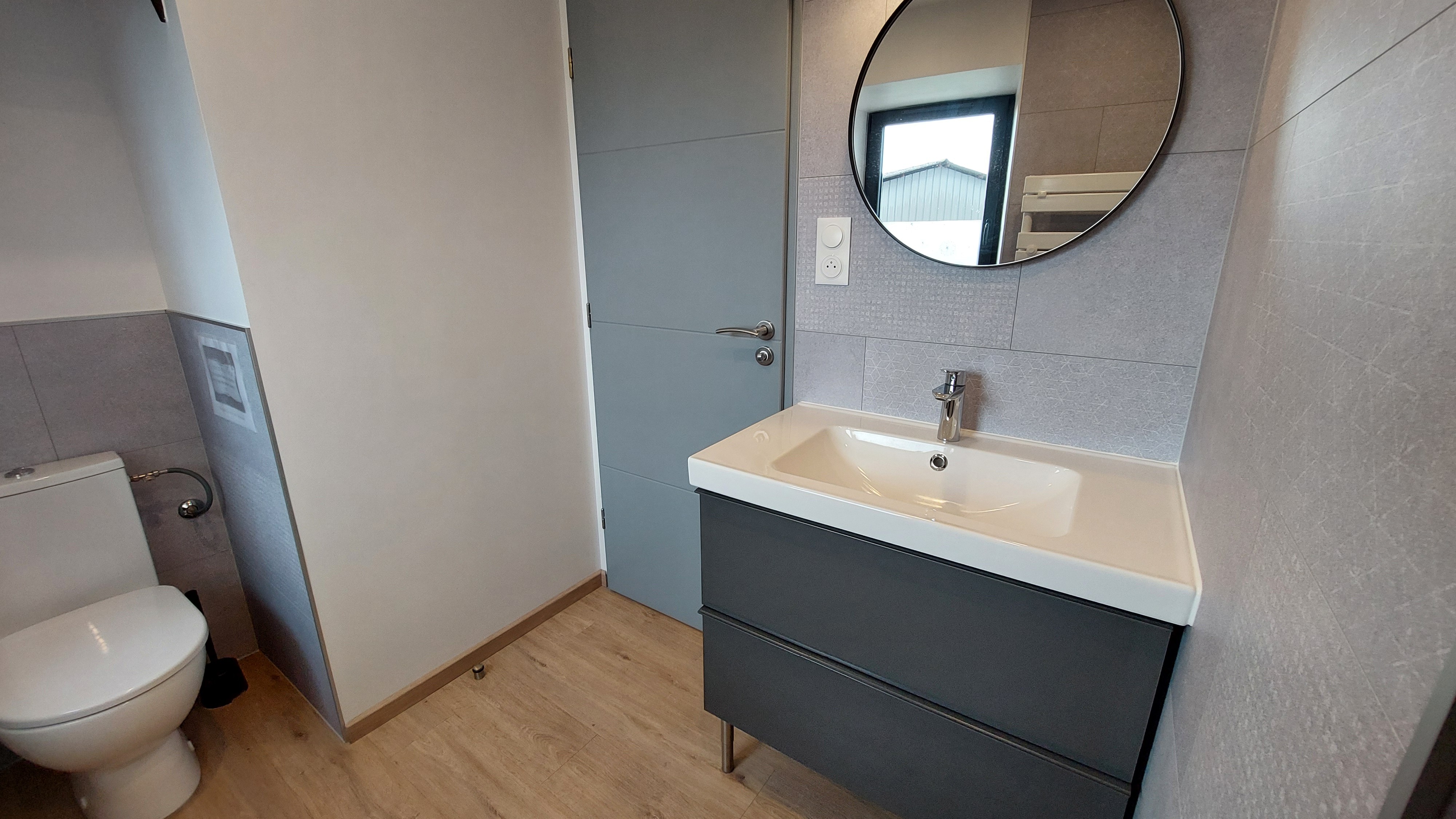 Salle de bain moderne avec douche, meuble vasque et toilettes privatives