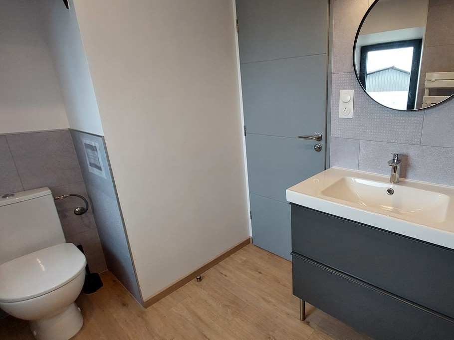 Salle de bain moderne avec douche, meuble vasque et toilettes privatives