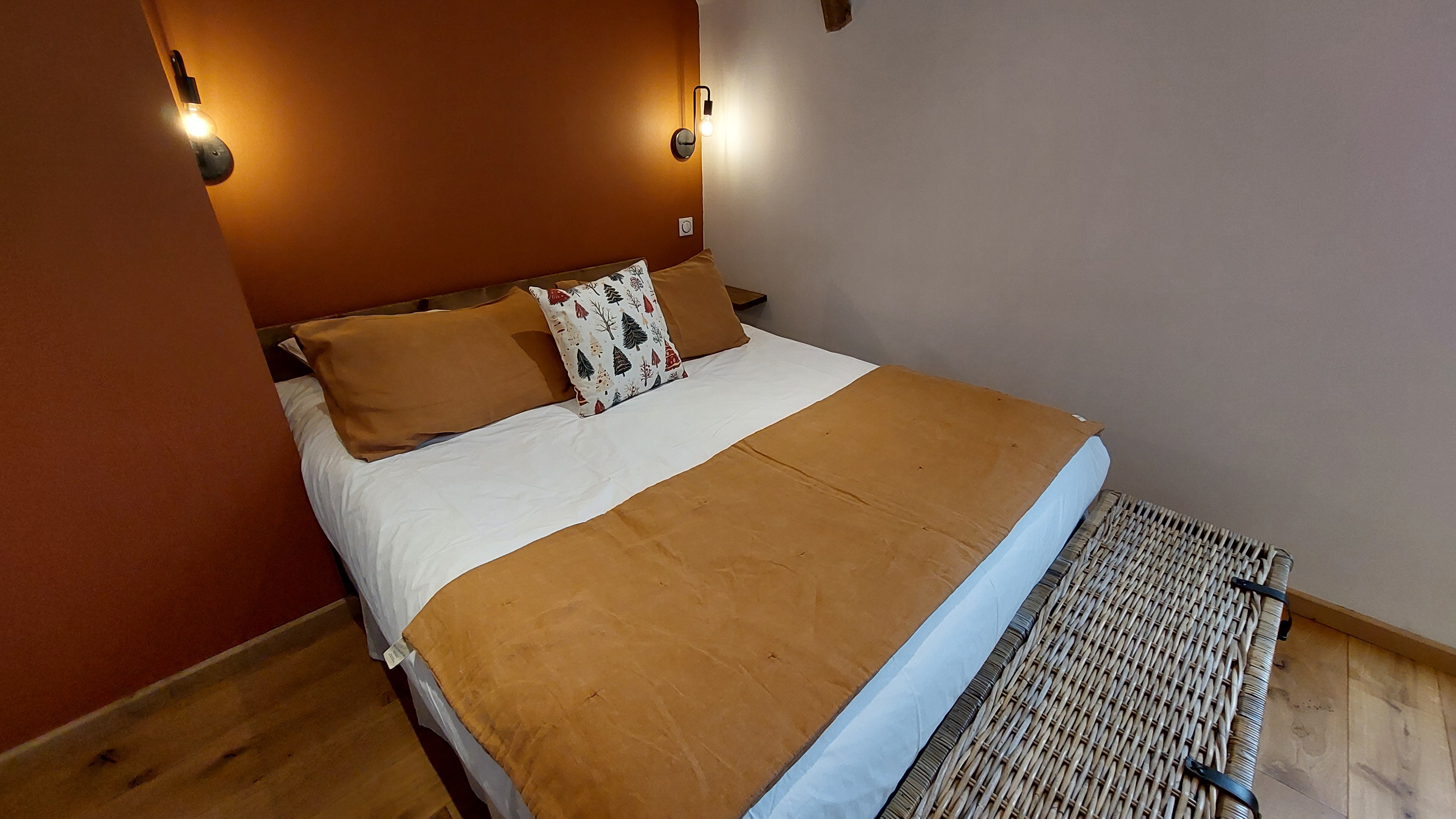 Double bed with warm linen and cocooning atmosphere in a nature guest room