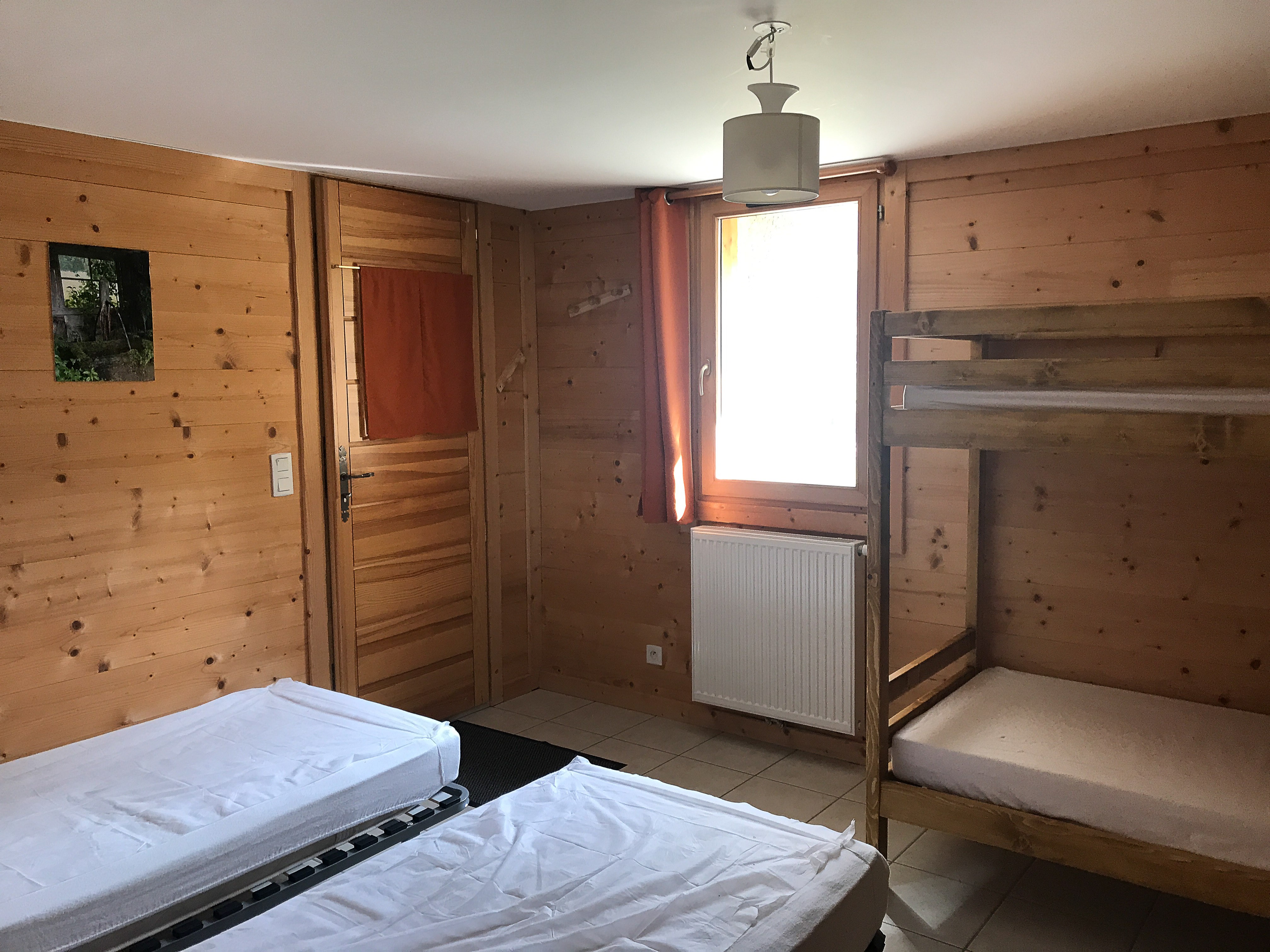 Chambre sous la terrasse avec lits superposés et lits jumeaux, accès extérieur