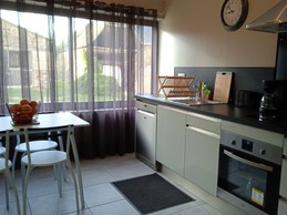 Cuisine toute équipée avec coin repas et vue sur la ferme