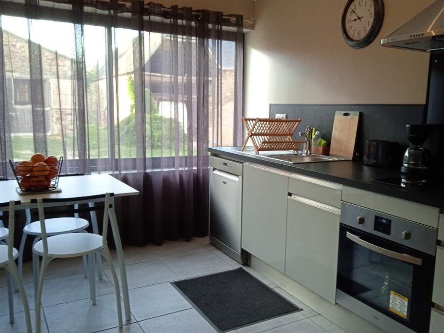 Cuisine toute équipée avec coin repas et vue sur la ferme