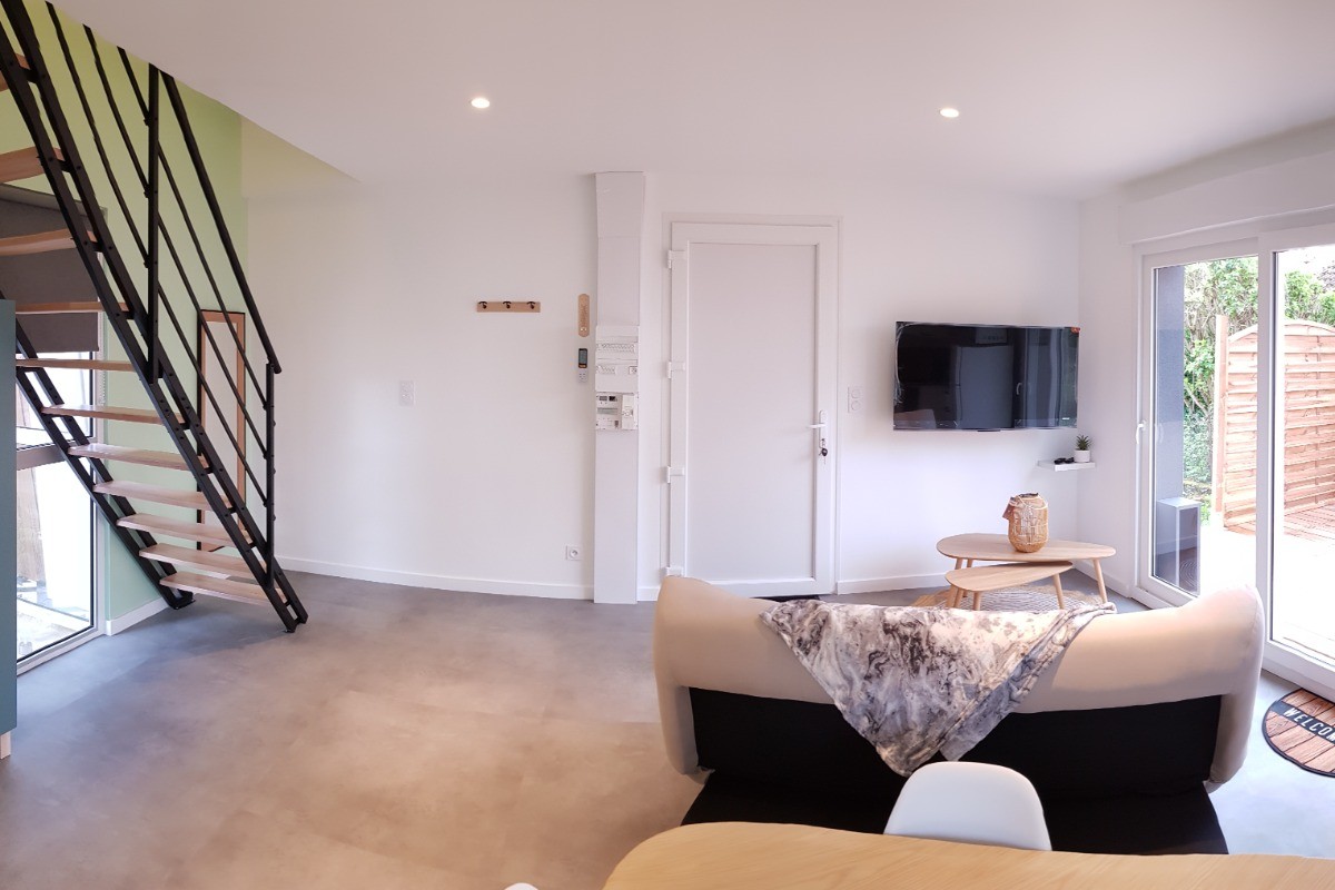 Pièce de vie au rez-de-chaussée avec coin salon avec TV, et coin cuisine et sa table à manger.  Canapé convertible pour 2 personnes. Terrasse en bois accessible par un portillon ou par la baie vitrée.