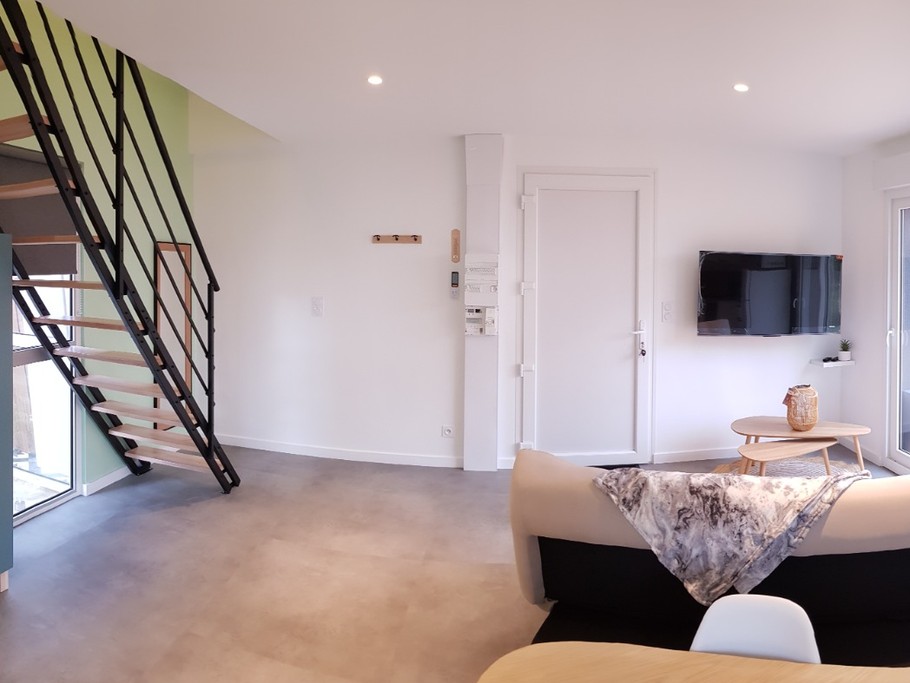Pièce de vie au rez-de-chaussée avec coin salon avec TV, et coin cuisine et sa table à manger. Canapé convertible pour 2 personnes. Terrasse en bois accessible par un portillon ou par la baie vitrée.