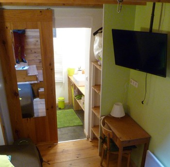 salon avec TV et bureau et communicant avec la SDE-WC
