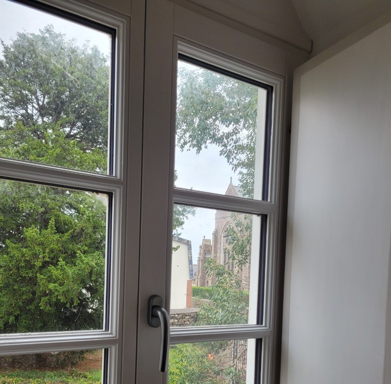 Chauvin, location, Clévacances, Paimpol, Plounez, chambre étage droite lit 160 avec bureau, vue de la fenêtre sur cour et église du bourg de Plounez