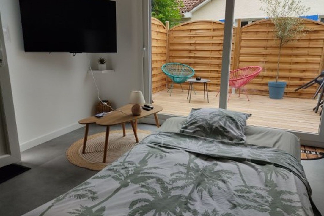 Pièce de vie au rez-de-chaussée avec coin salon avec TV, et coin cuisine et sa table à manger.  Canapé convertible pour 2 personnes. Terrasse en bois accessible par un portillon ou par la baie vitrée.