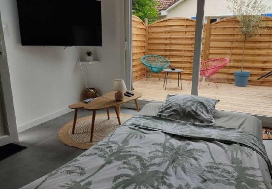 Pièce de vie au rez-de-chaussée avec coin salon avec TV, et coin cuisine et sa table à manger. Canapé convertible pour 2 personnes. Terrasse en bois accessible par un portillon ou par la baie vitrée.