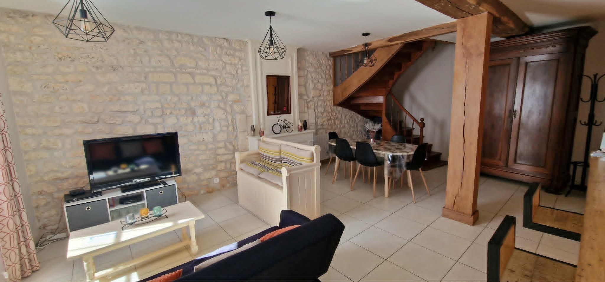 The 30 m² living room with fitted kitchen, lounge and dining area at Logis de La Passerelle in Port d'Envaux, Charente maritime.