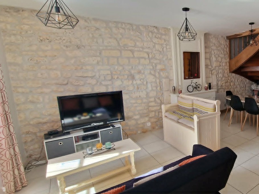 The 30 m² living room with fitted kitchen, lounge and dining area at Logis de La Passerelle in Port d'Envaux, Charente maritime.