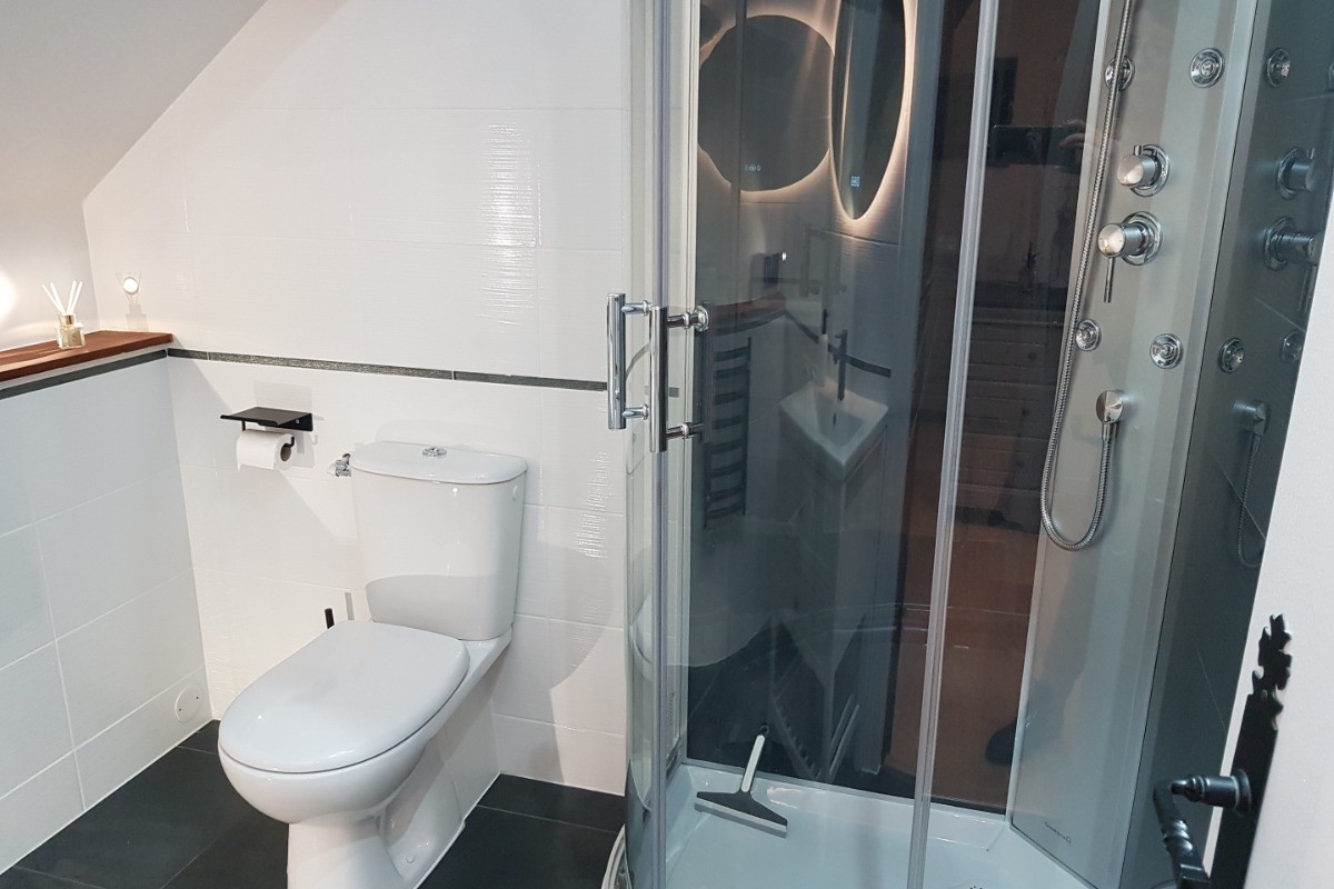 Salle d'eau attenante à la suite parentale avec douche balnéo et WC.