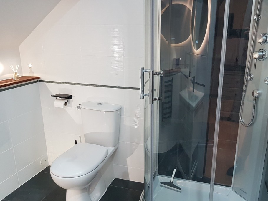 Salle d'eau attenante à la suite parentale avec douche balnéo et WC.