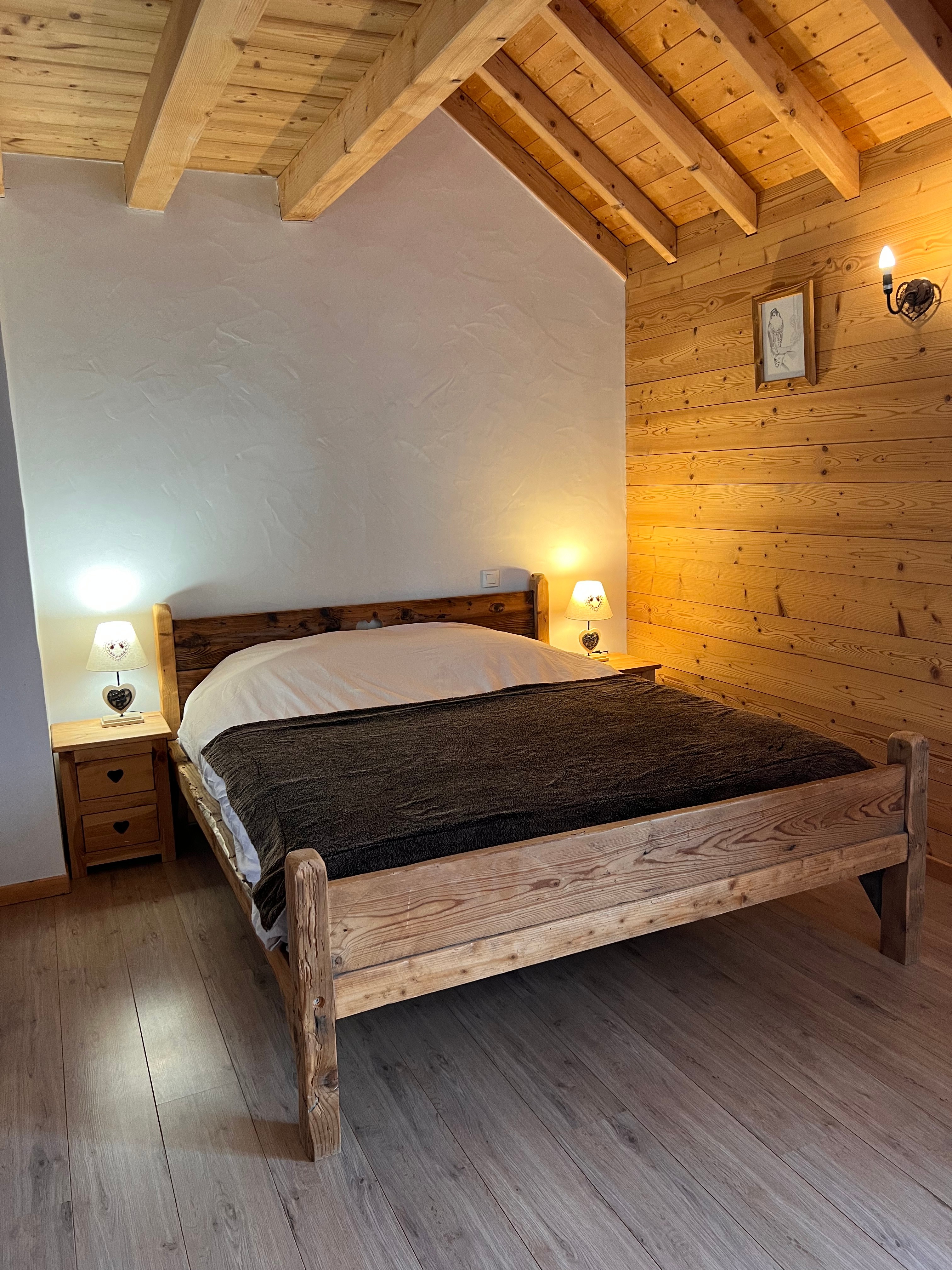 Chambre 2 avec un lit de 160x200 cm, un placard intégré et un balcon offrant une vue sur les pistes de ski et les montagnes.