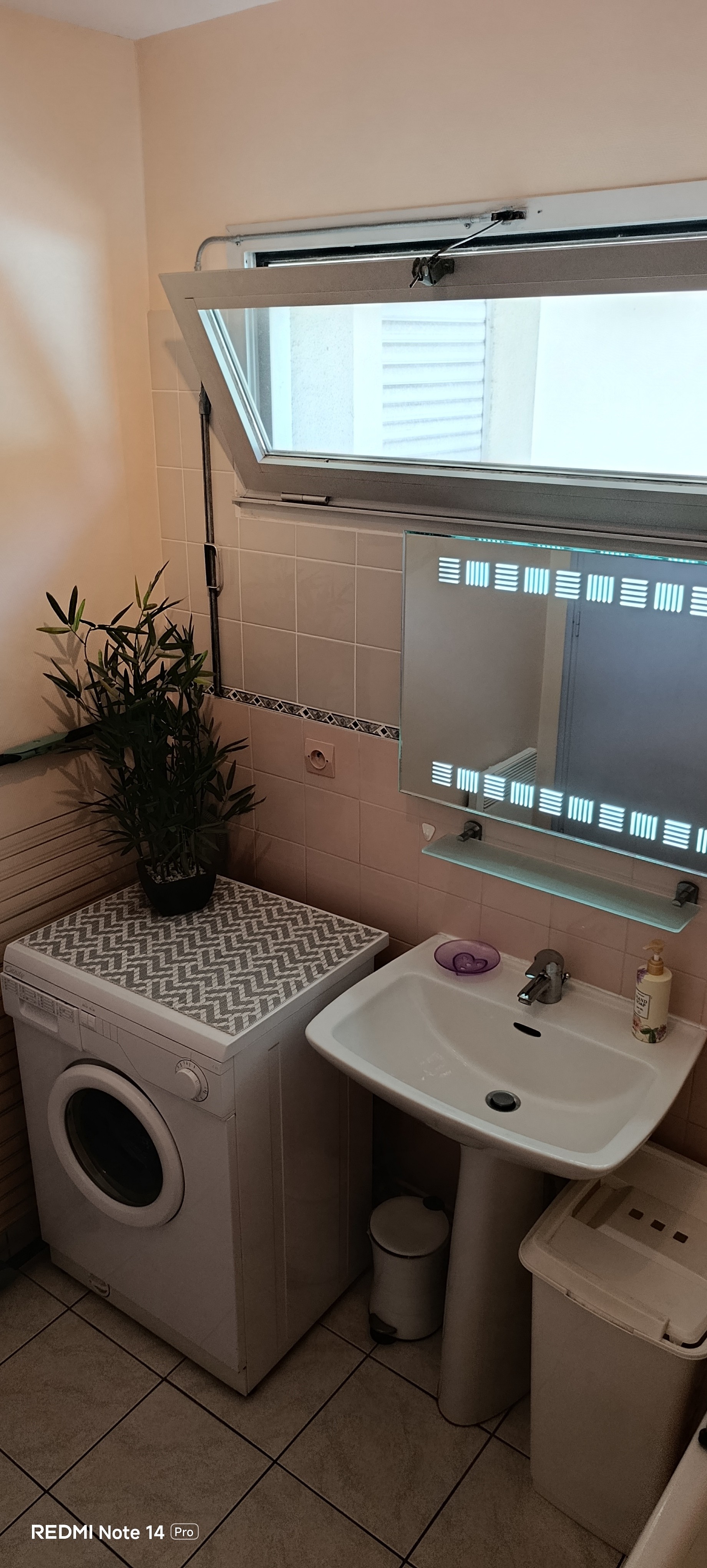 The bathroom with a bath, washing machine and storage shelves