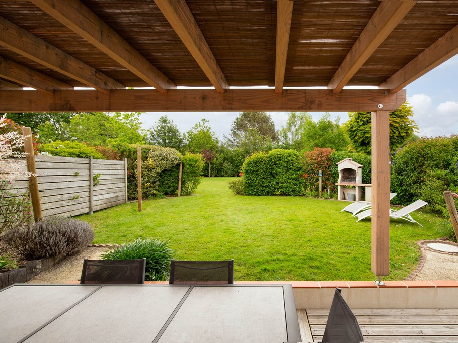 Jardin privatif avec pergola, hamac, salon de jardin, bain de soleil, barbecue et fils à linge.