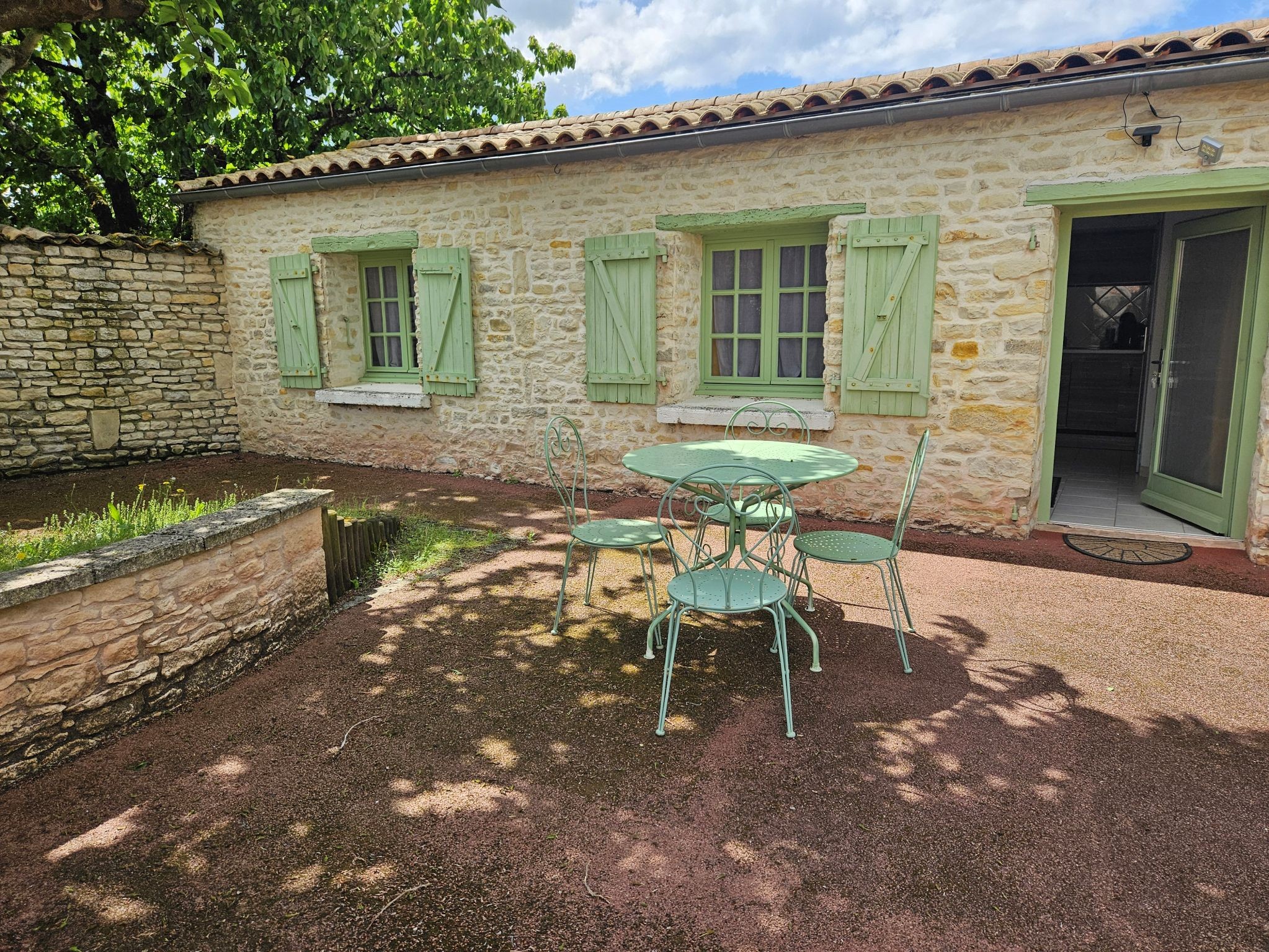 Façade et Entrée du gîte avec le coin privé avec une table et des chaises pour prendre ses repas