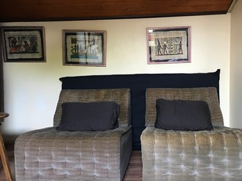 Au fond de la chambre, deux fauteuils.