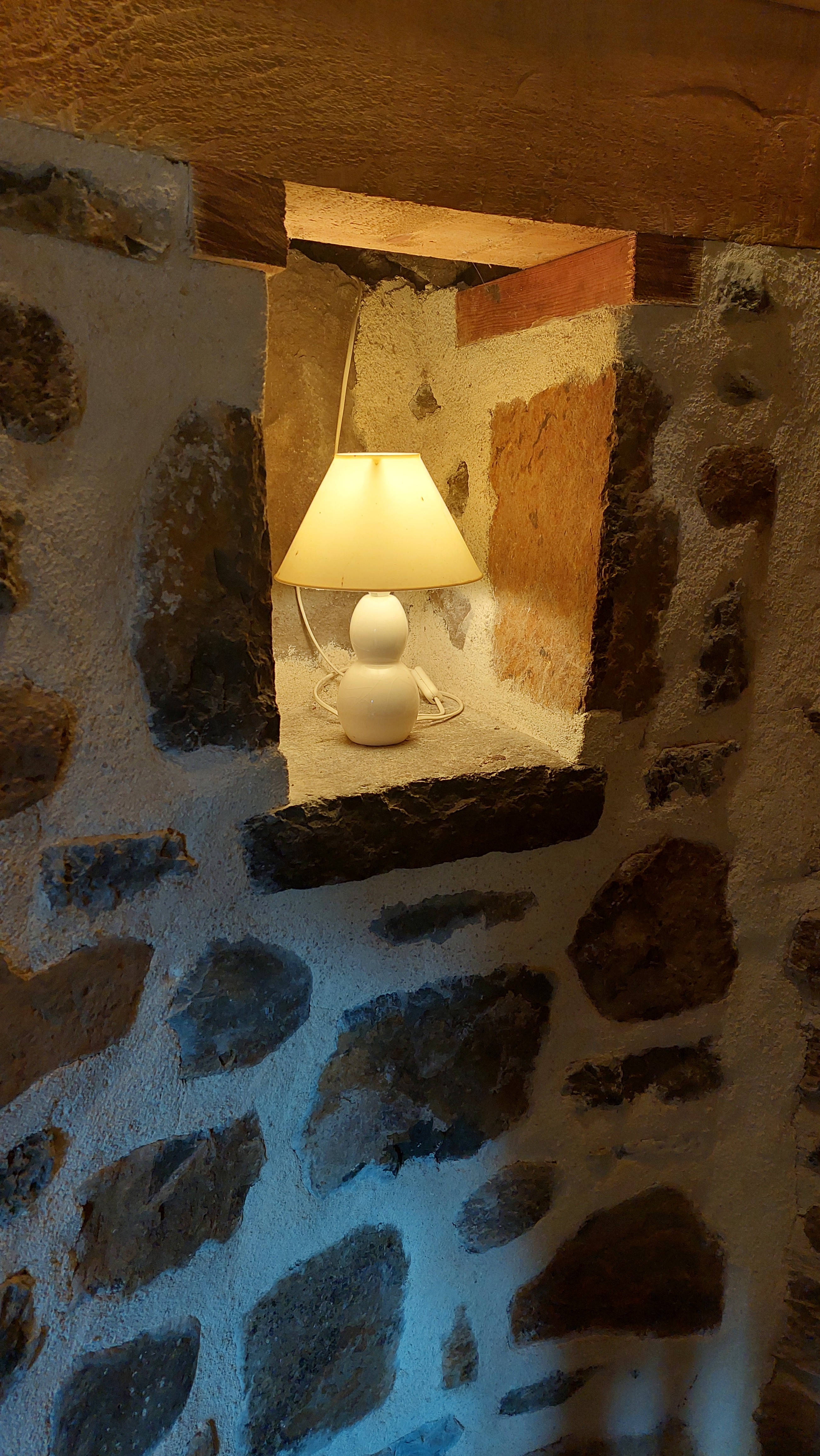 Detail of stone niche with lamp in character house