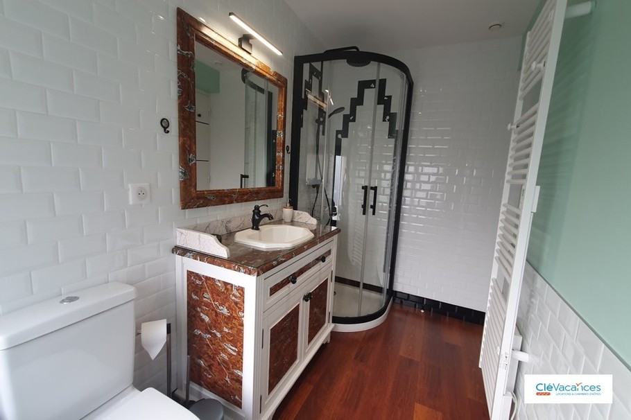 Clévacances, la salle d'eau avec WC, douche art déco et meuble vasque peint à la main en faux marbre