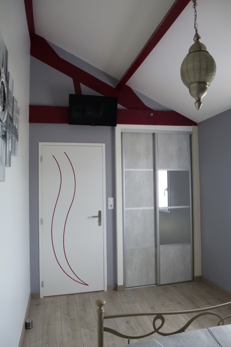Grey bedroom with double bed (140), wardrobe and TV.
