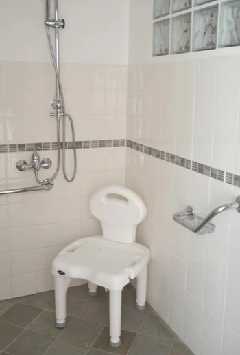 Douche à l'italienne avec fauteuil pour PMR