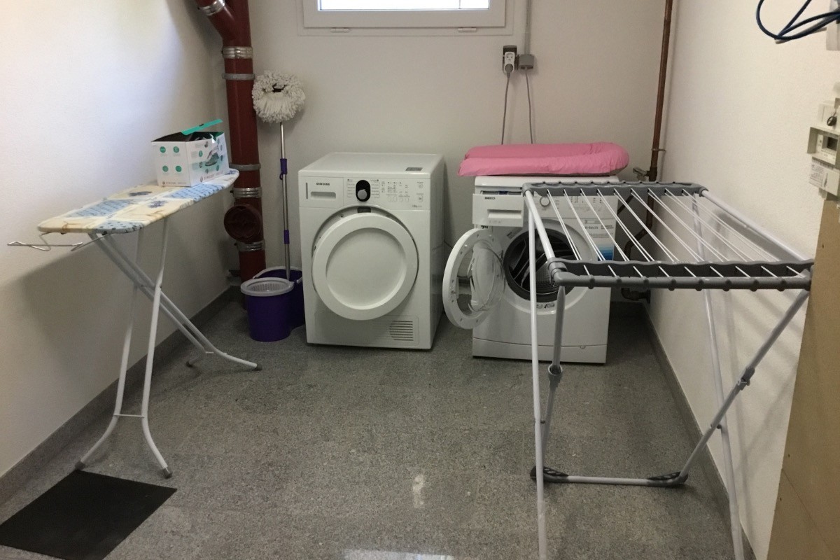 Buanderie privée au sous sol avec lave-linge et sèche-linge, table à repasser + fer à repasser