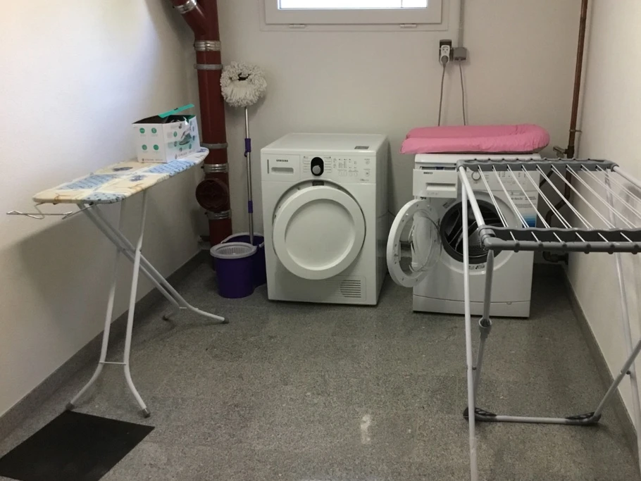 Buanderie privée au sous sol avec lave-linge et sèche-linge, table à repasser + fer à repasser