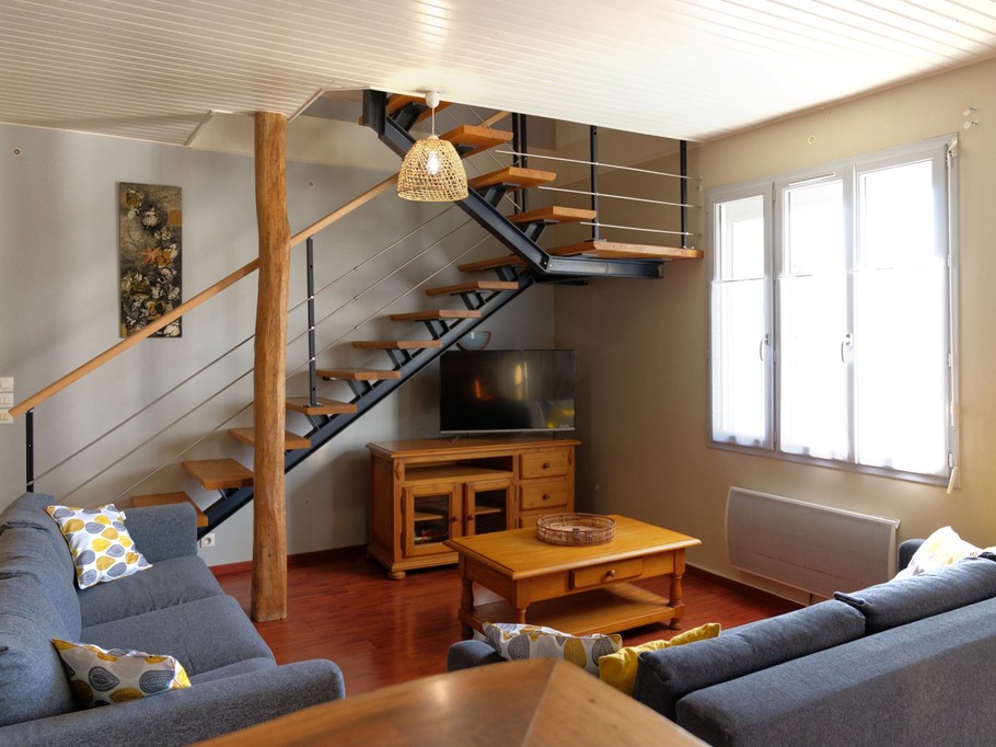 Salon avec escalier qui accède aux 3 chambres
