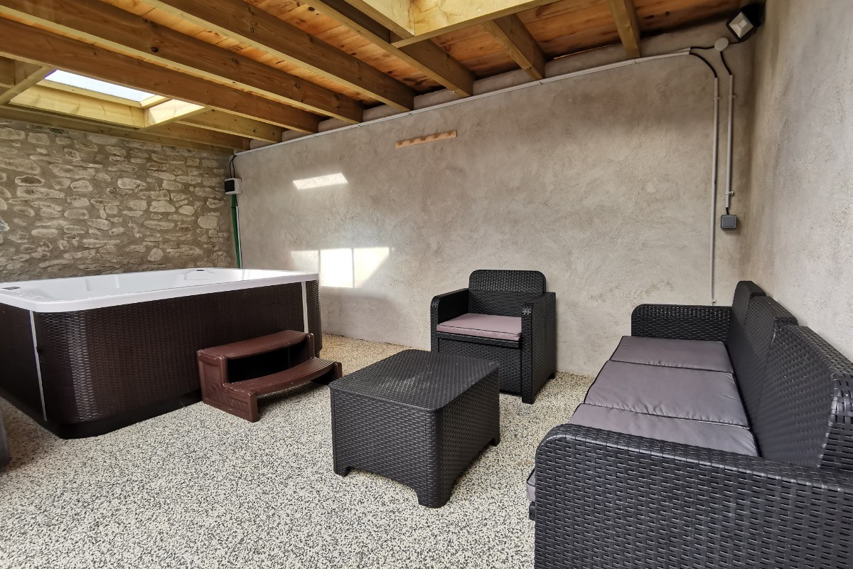 Espace couvert avec salon de jardin et SPA