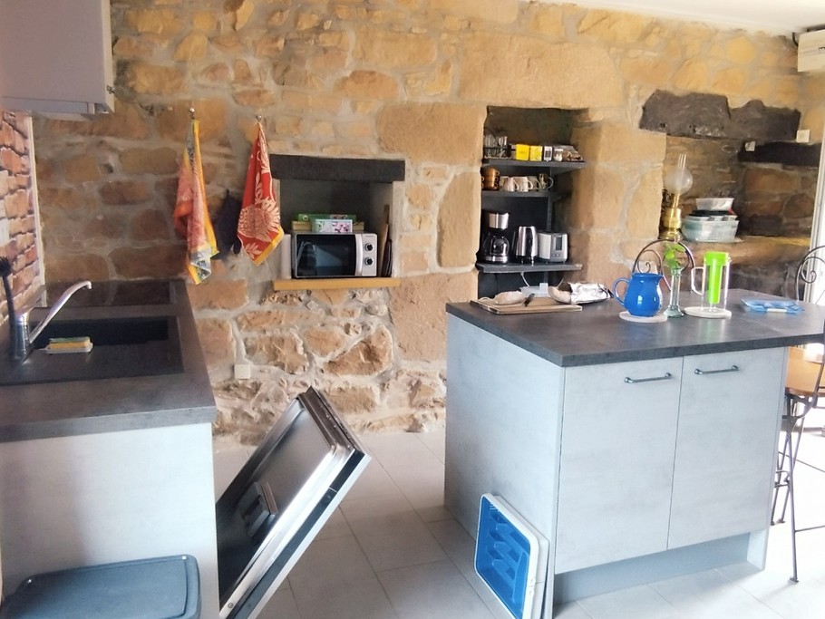 La cuisine équipée, son îlot central et ses niches lave vaisselle