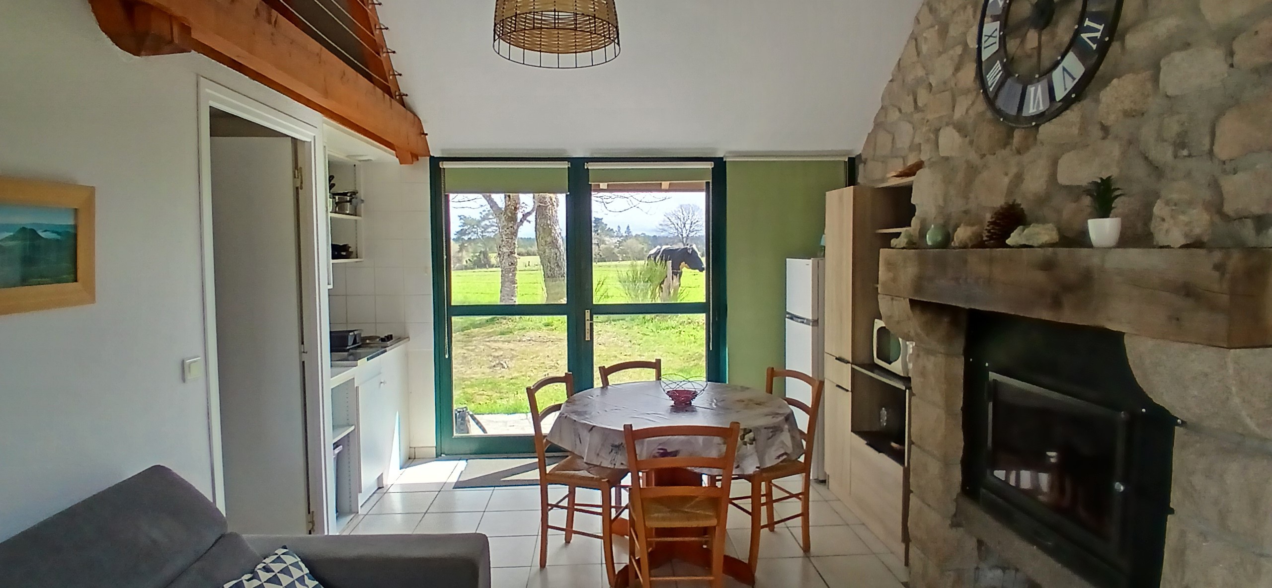 Etang de Farges, Saint Germain près Herment, Chalet vert - Pièce de vie avec cheminée et canapé convertible dans le salon