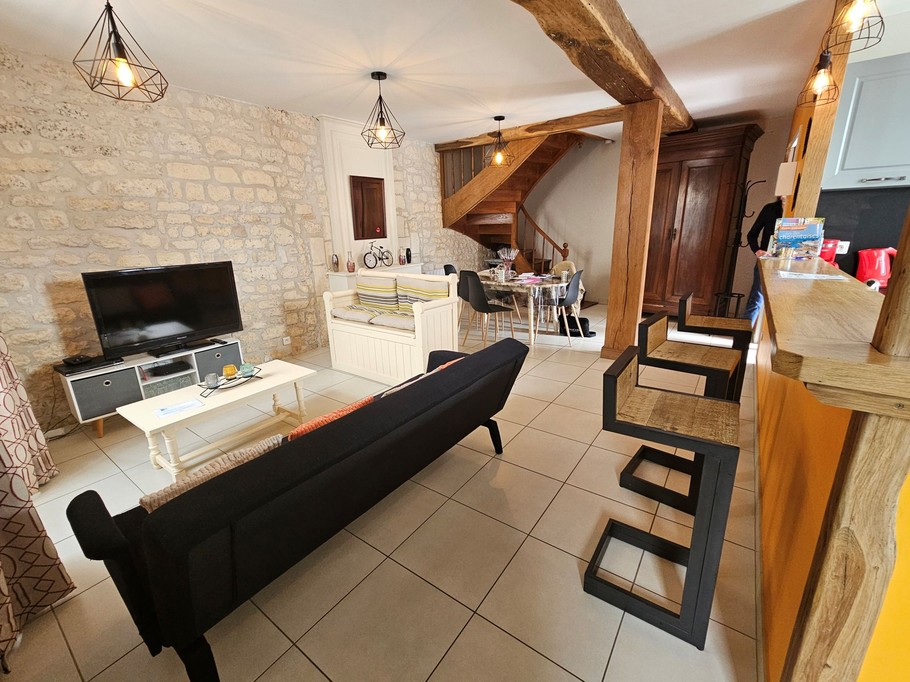 The 30 m² living room with fitted kitchen, lounge and dining area at Logis de La Passerelle in Port d'Envaux, Charente maritime.