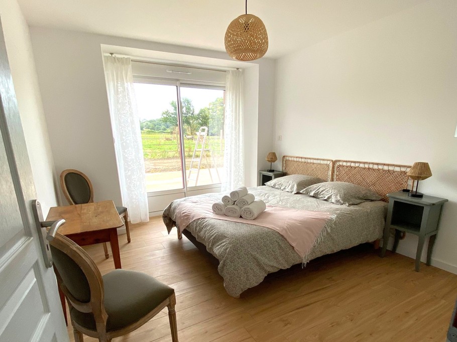 Chambre 1 au RDC de plain pied avec lit 160 cm et rangements. Salle d'eau communicante. WC séparé.