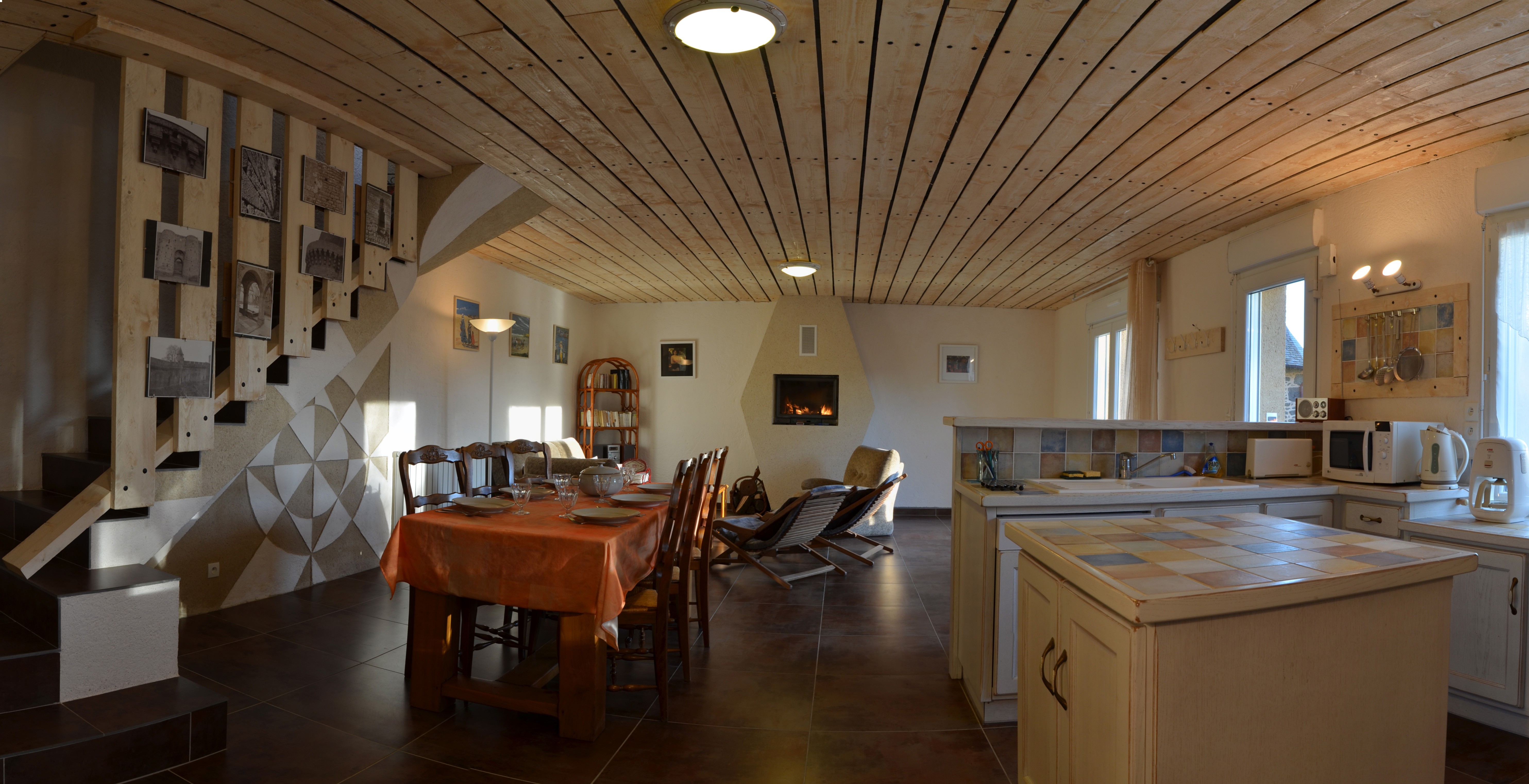 Grande pièce de vie avec cuisine, séjour et salon. Poêle à bois.